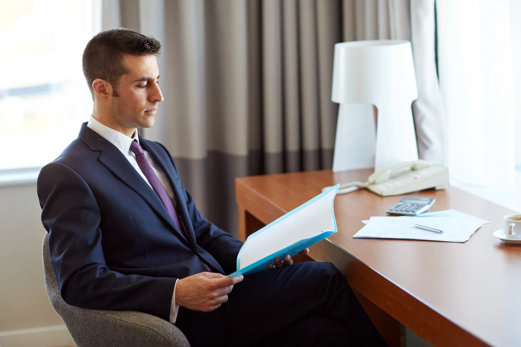 Professional reviewing compliance documents at a clean desk