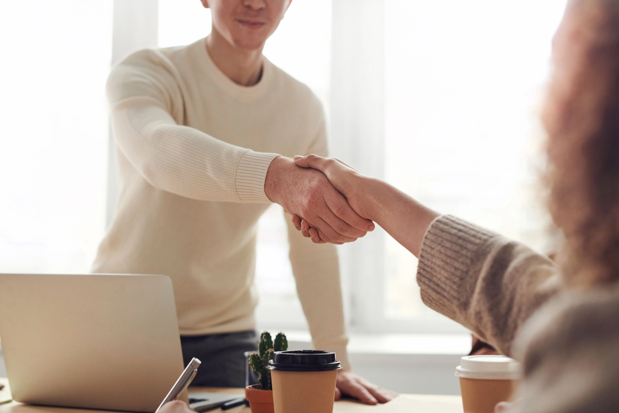 Business partners shaking hands over a signed agreement