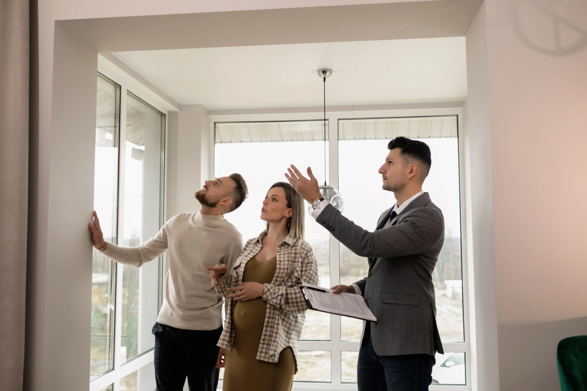 Real estate agent showing a project to a prospective buyer couple